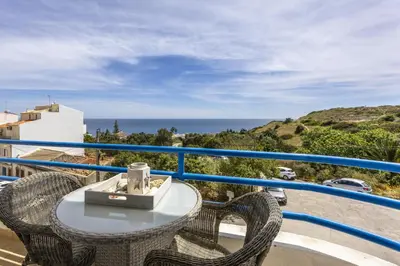 a balcony with a table and chairs and the ocean at CoolHouses Algarve Luz, 2 Bed top floor flat, amazing sea view, central. Delicia do Sol in Luz