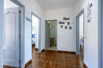 a hallway with two doors and a tile floor at CoolHouses Algarve Luz, 2 Bed top floor flat, amazing sea view, central. Delicia do Sol in Luz
