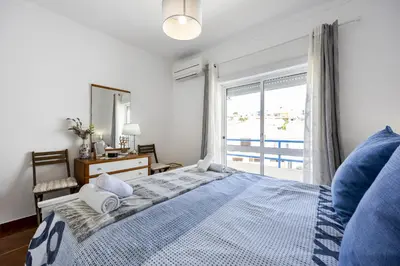 a bedroom with a bed and a large window at CoolHouses Algarve Luz, 2 Bed top floor flat, amazing sea view, central. Delicia do Sol in Luz