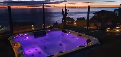 a hot tub on a balcony with a view of the ocean at Casa da Rocha in Paul do Mar