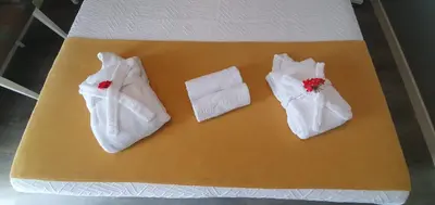 three white towels are sitting on a bed at Casa da Rocha in Paul do Mar