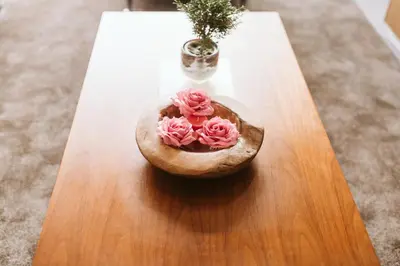 a wooden bowl with pink roses on a table at Madeira Xhic Apartment by Amazing Madeira in Funchal