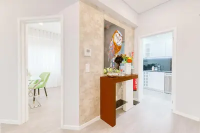 a living room with a table and a kitchen at Madeira Xhic Apartment by Amazing Madeira in Funchal