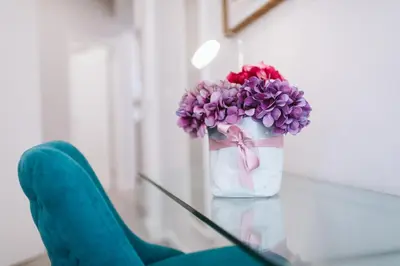 a vase with purple flowers sitting on a table at Madeira Xhic Apartment by Amazing Madeira in Funchal