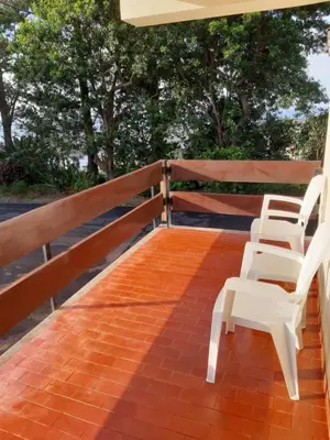 four white chairs sitting on a wooden deck at Apartamentos Matur Flats 2 in Machico