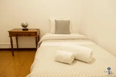 a bed with two pillows on it with a table at Casa da Edite in Ponta do Sol