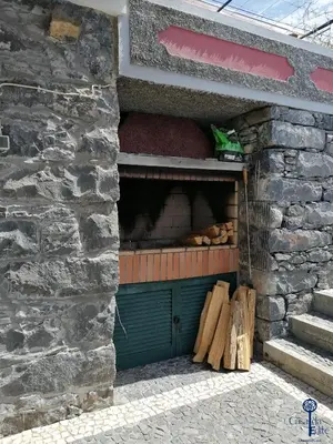 a barn with a green door and some wood at Casa da Edite in Ponta do Sol