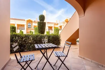 a patio with two chairs and a table with wine glasses at Baia da Luz- ground floor apartment in Luz