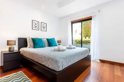 a bedroom with a large bed with blue pillows at Baia da Luz- ground floor apartment in Luz