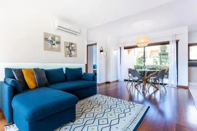 a living room with a blue couch and a table at Baia da Luz- ground floor apartment in Luz
