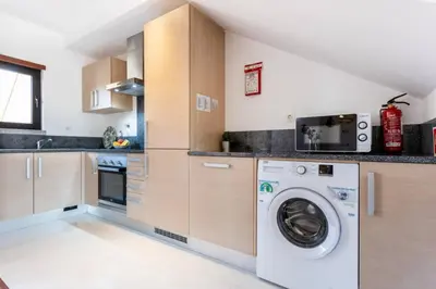 a kitchen with a washer and a washing machine at Baia da Luz- ground floor apartment in Luz