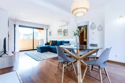 a living room with a table and a blue couch at Baia da Luz- ground floor apartment in Luz