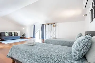 a living room with two beds and a couch at Baia da Luz - Poolview Loft Aparment in Luz