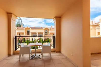 a balcony with a table and chairs and a large window at Baia da Luz - Poolview Loft Aparment in Luz