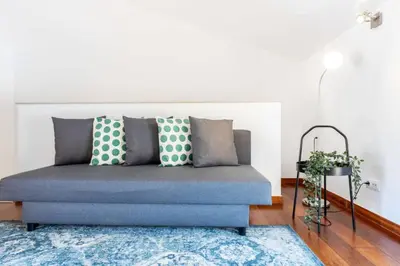 a blue couch in a living room with a blue rug at Baia da Luz - Poolview Loft Aparment in Luz