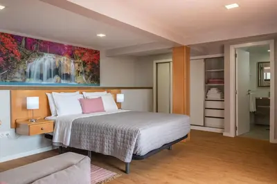 a bedroom with a bed and a painting on the wall at Casa do Miradouro -Fantástico Estúdio in Santa Cruz