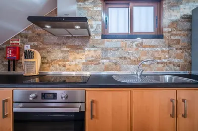 a kitchen with a sink and a stove at Casa do Miradouro -Fantástico Estúdio in Santa Cruz