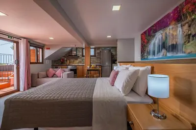 a bedroom with a bed and a living room at Casa do Miradouro -Fantástico Estúdio in Santa Cruz