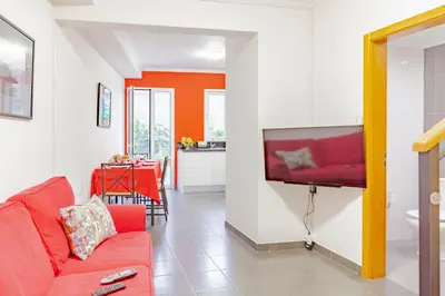 a living room with a red couch and a tv at Harmony Apartment in Funchal