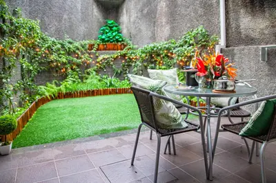 a patio with a table and chairs and a small garden at Harmony Apartment in Funchal