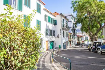 a city street with buildings and a car on the road at Harmony Apartment in Funchal