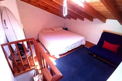 a bedroom with a bed and a chair in a room at Casinha de Aldeia no coração da Costa Vicentina in Vila do Bispo