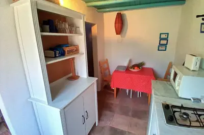 a small kitchen with a table and a kitchen with a microwave at Casinha de Aldeia no coração da Costa Vicentina in Vila do Bispo
