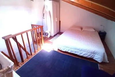 a bedroom with a bed in a room with a staircase at Casinha de Aldeia no coração da Costa Vicentina in Vila do Bispo