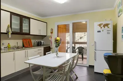 a kitchen with a table and a white refrigerator at Apartamento Jade in Caniço