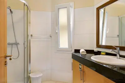 a bathroom with two sinks and a mirror and a shower at Apartamento Jade in Caniço