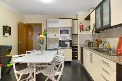 a kitchen with a white table and chairs in it at Apartamento Jade in Caniço