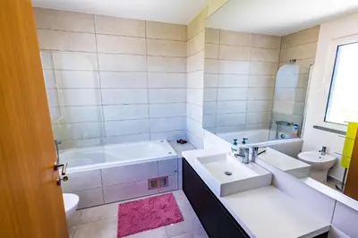 a bathroom with a tub and a sink and a bath tub at Sun and Sea II in Caniço