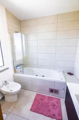 a bathroom with a tub and a toilet and a sink at Sun and Sea II in Caniço
