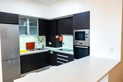 a kitchen with dark wood cabinets and appliances at Sun and Sea I in Caniço