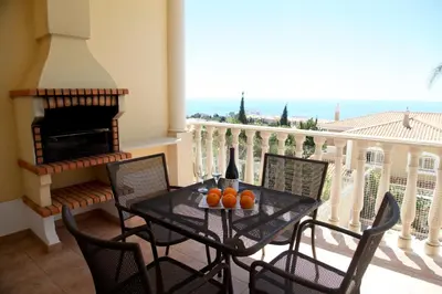 a balcony with a table with oranges on it at Vila G, Mira Luz in Luz