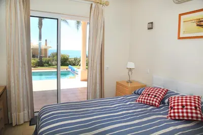 a bedroom with a bed and a view of a pool at Vila G, Mira Luz in Luz