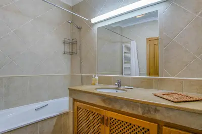 a bathroom with a sink and a mirror and a tub at Vila Bela Nova Acácias 22 in Luz