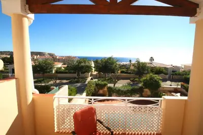 a balcony with a chair and a view of the ocean at Vila Bela Nova Acácias 22 in Luz