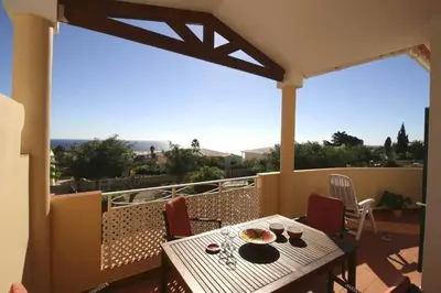 a patio with a table and chairs on a balcony at Vila Bela Nova Acácias 22 in Luz