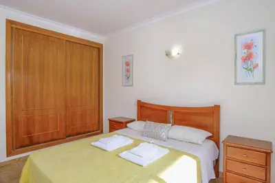 a bedroom with two beds and a wooden door at Vila Bela Nova Acácias 22 in Luz