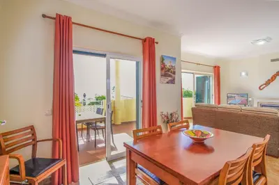a living room with a table and a dining room at Vila Bela Nova Acácias 22 in Luz