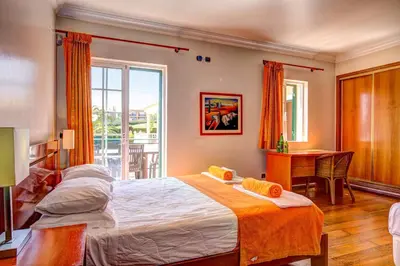 a bedroom with a bed and a table and a window at Villa Daisy by Villa Plus in Lagos