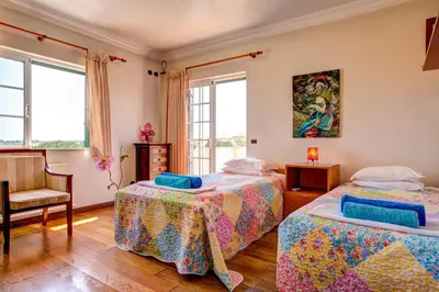 a bedroom with two beds and a chair at Villa Daisy by Villa Plus in Lagos