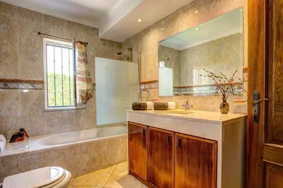 a bathroom with a toilet and a sink and a tub at Villa Daisy by Villa Plus in Lagos