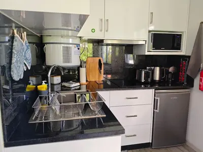 a kitchen with dish drying racks and a sink at Vаrаndаs dо Sоl-Vista relaxante entre mar e montanha in Ponta do Sol