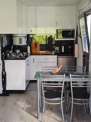 a kitchen with a table and chairs in it at Vаrаndаs dо Sоl-Vista relaxante entre mar e montanha in Ponta do Sol