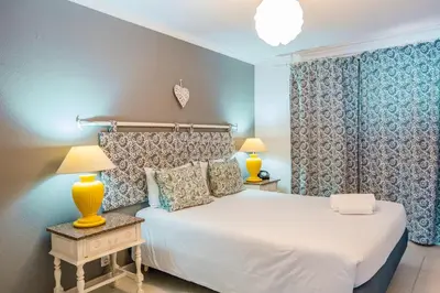 a bedroom with a white bed and two lamps at Casa do Cais in Calheta