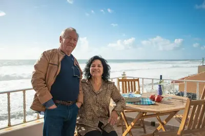 a man and a woman standing on the beach at Casa do Cais in Calheta