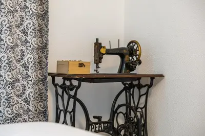 a sewing machine sitting on a table next to a wall at Casa do Cais in Calheta