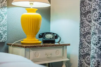 a yellow lamp on a table with a clock on it at Casa do Cais in Calheta